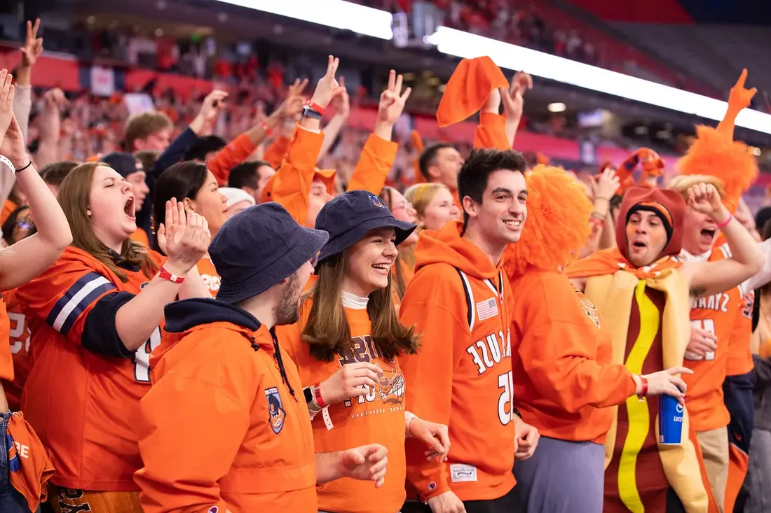 Group of sports fans in a stadium cheering.